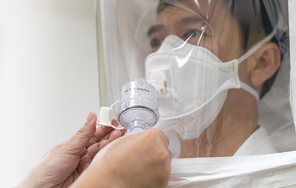 Respirator fit testing procedure being conducted by a professional